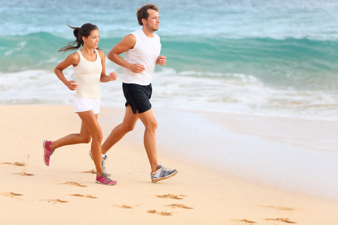 Running Couple Jogging on Beach Exercising Sport